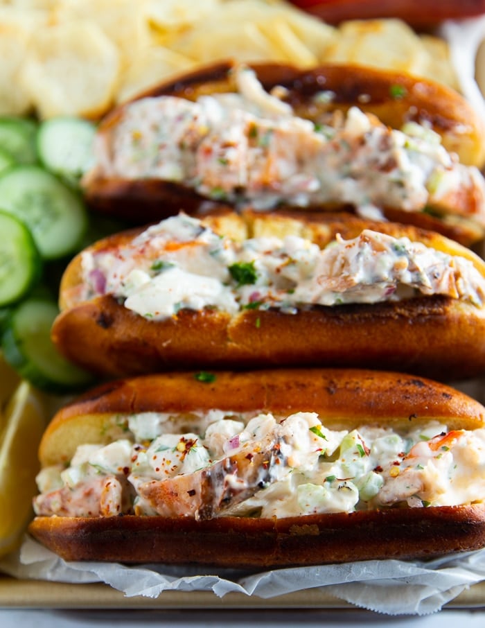 close up of a stack of lobster rolls showing the lobster roll filling and the toasted buns