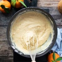 A whisk whisking in the batter into the same bowl.