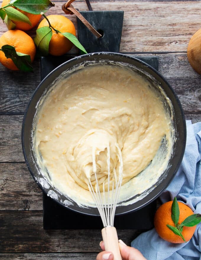 A whisk whisking in the batter into the same bowl.