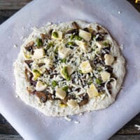 Pizza with cheese and mushrooms before baking.