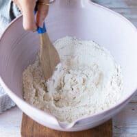 Mixing the pizza dough using a wooden spoon