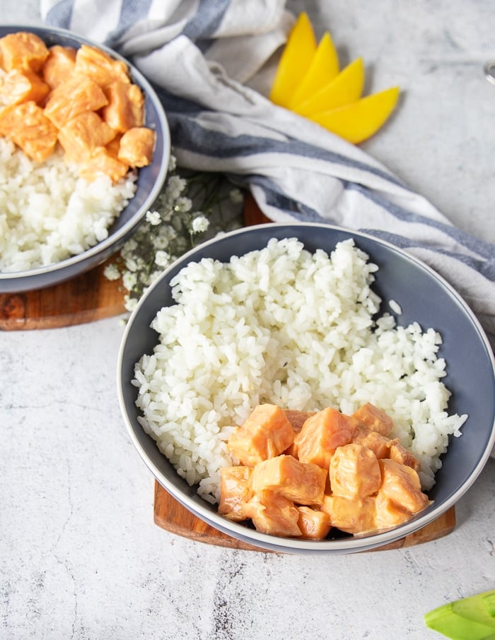 Add the spicy salmon mixture on the side of the rice to gradually assemble the sushi bowl