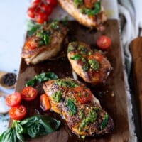 chicken caprese on a wooden board close up showing the golden crust and shine on the chicken