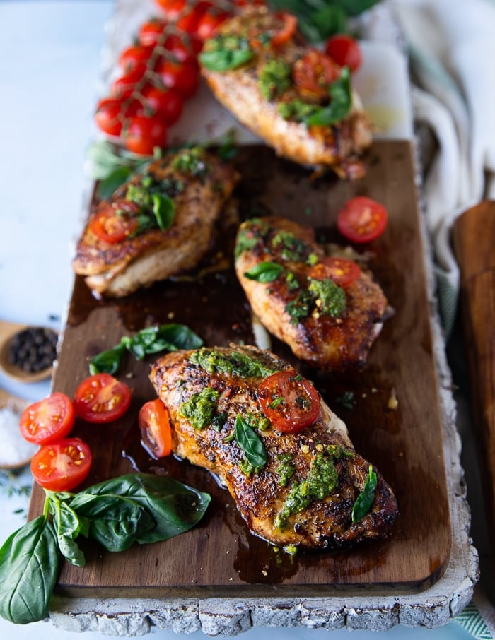 chicken caprese on a wooden board close up showing the golden crust and shine on the chicken