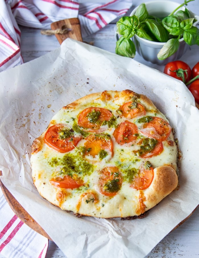 caprese pizza out of the oven and ready for more pesto and balsamic if needed