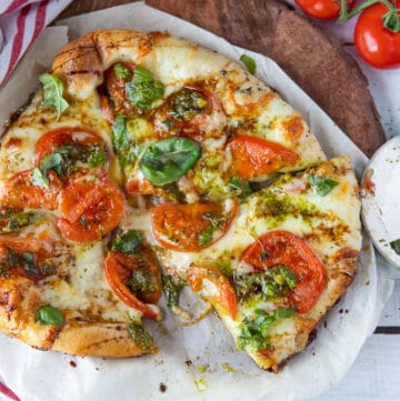 Finished Caprese Pizza on a wooden board.