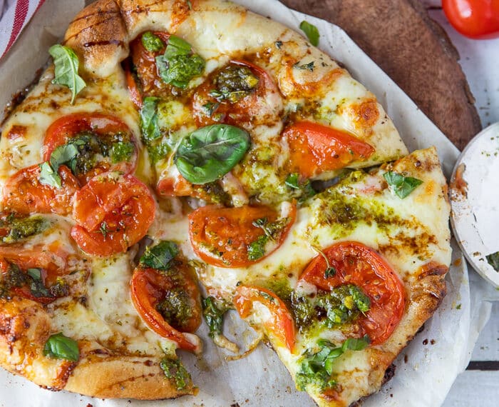 Finished Caprese Pizza on a wooden board.