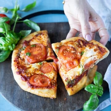 A hand holding a slice of perfectly cooked air fryer pizza