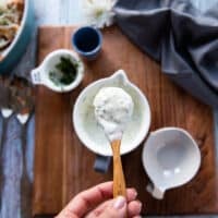 the coleslaw dressing mixed together in a bowl and a spoon showing the final dressing