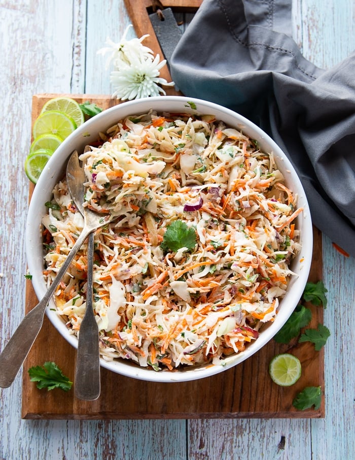 two spoons mixing up the dressing with the slaw to make the fish taco slaw recipe