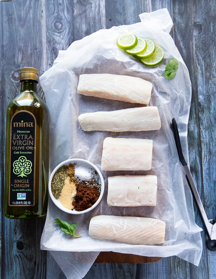 ingredients for mahi mahi tacos including mahi mahi fish, a bowl of spice and olive oil