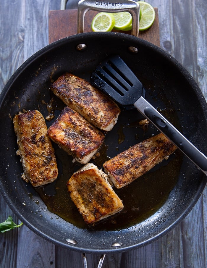 Perfectly cooked mahi mahi fish in a skillet, all crispy and browned up