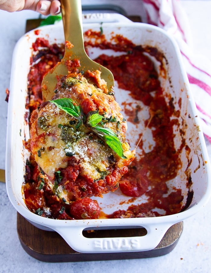 a serving spoon showing a piece of veal parmesan close up and ready to be served