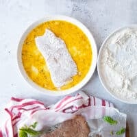 the floured veal cutlet added to the egg plate for coating