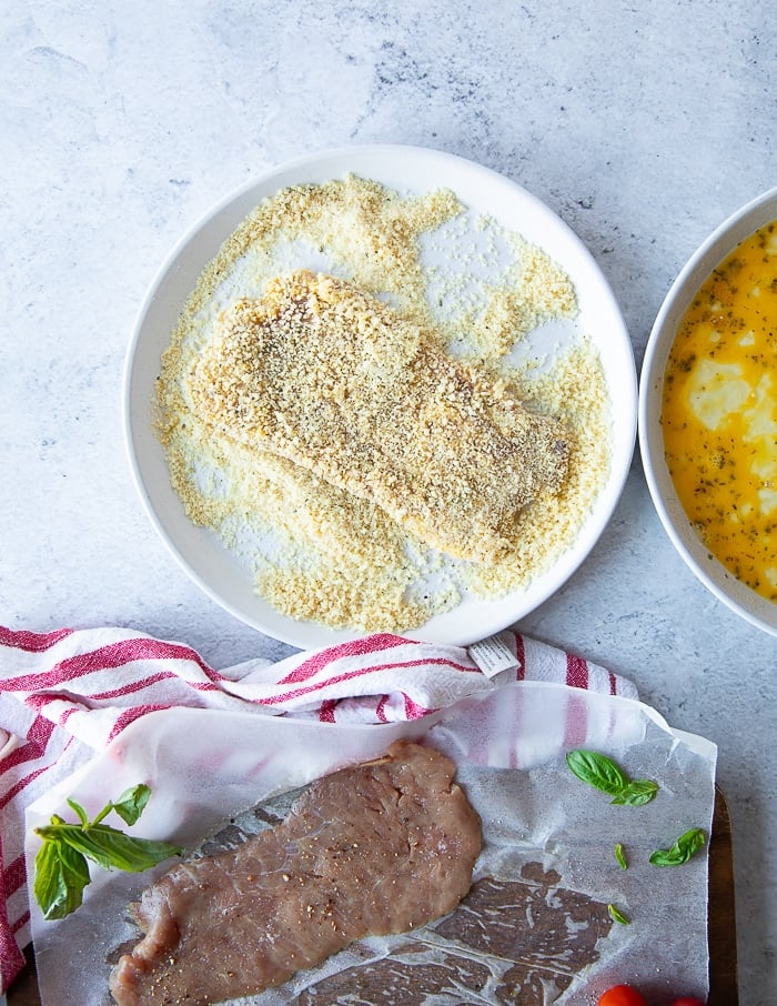 the veal cutlet added to the breadcrumbs plate for breading and final coat