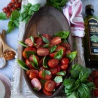 tomatoes scattered on a plate to make caprese with burrata