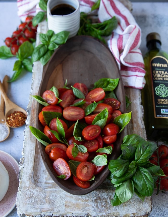 tomatoes scattered on a plate to make caprese with burrata