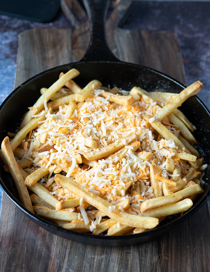 shredded cheese is added over the fries