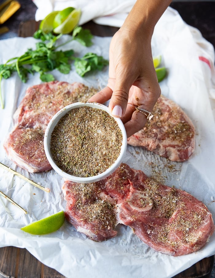 A hand showing a close up of the seasoning mix for carne asada recipe