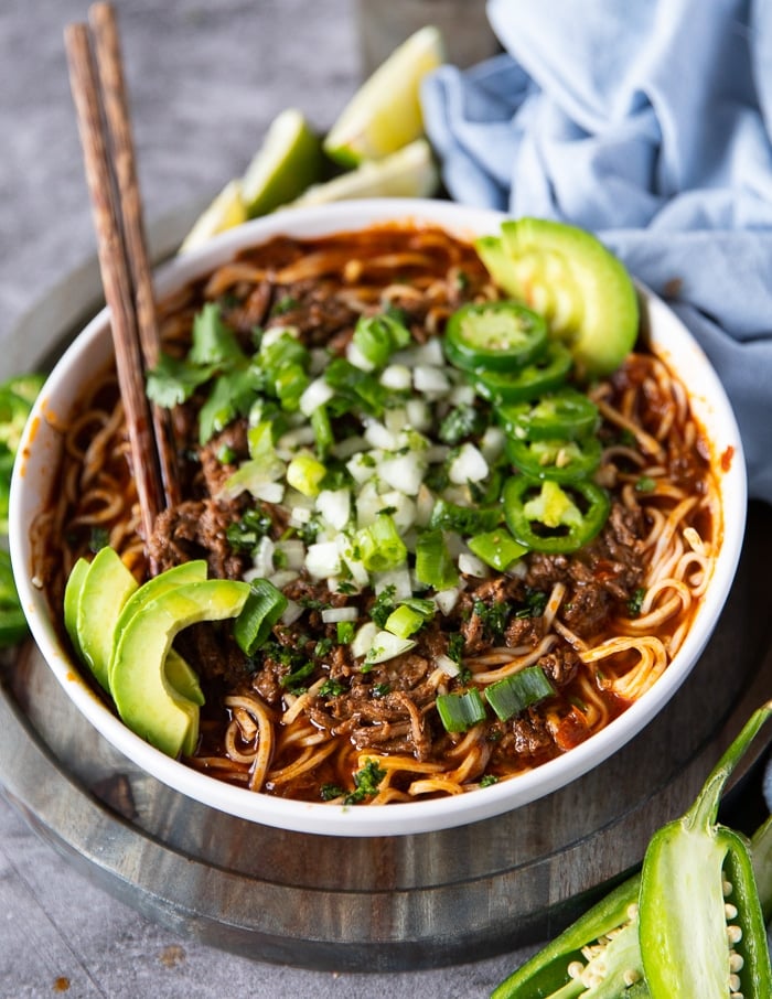 toppings added to finish off the birria ramen: avocados, onions, jalapeños, cilantro and lime wedges