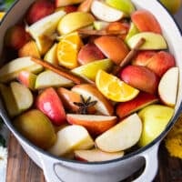 a large 7 quart pot filled with water and the apples, oranges and spices all added in