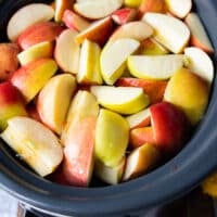 A large crock-pot filled with water, apples, oranges, whole spices, ready to make crock-pot apple cider