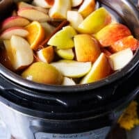 Instant Pot with water, apples, oranges, whole spices to make Homemade Apple Cider