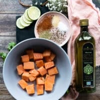 Ingredients for the salmon tacos including salmon cut up into chunks, olive oil, spice blend, lime