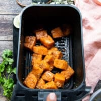 salmon placed in an air fryer basket to cook