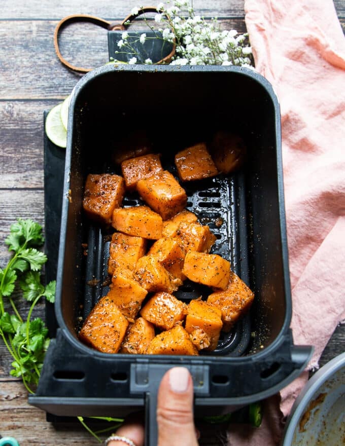 salmon placed in an air fryer basket to cook