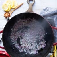 Onions sauteeing in a pan to make lamb stew