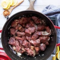 the lamb is added over the sauteed onions