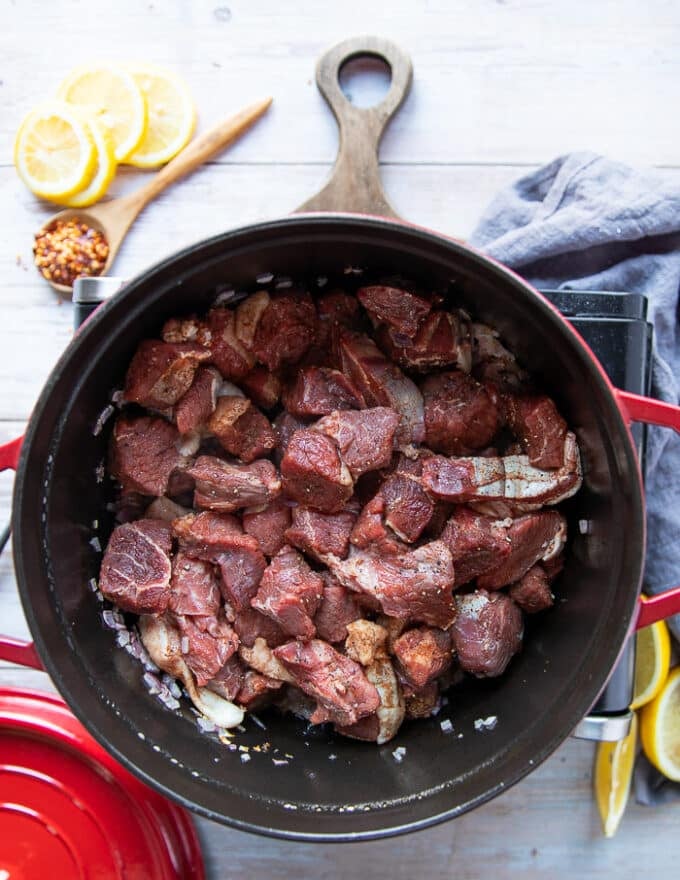 the lamb is added over the sauteed onions