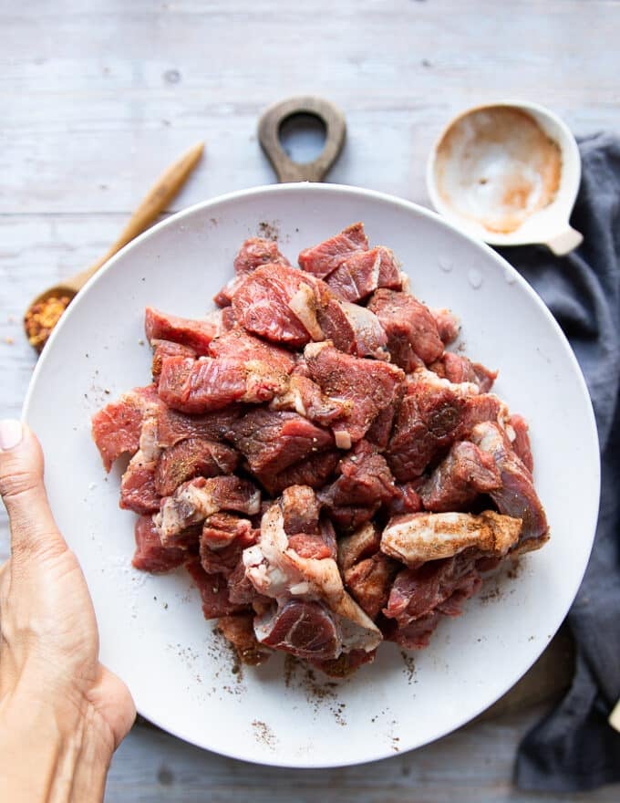 The Lamb tossed with spices in a bowl