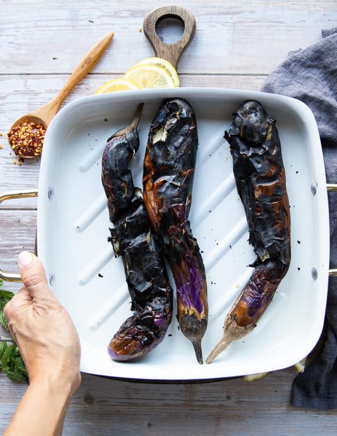 Fully charred eggplants on a plate 