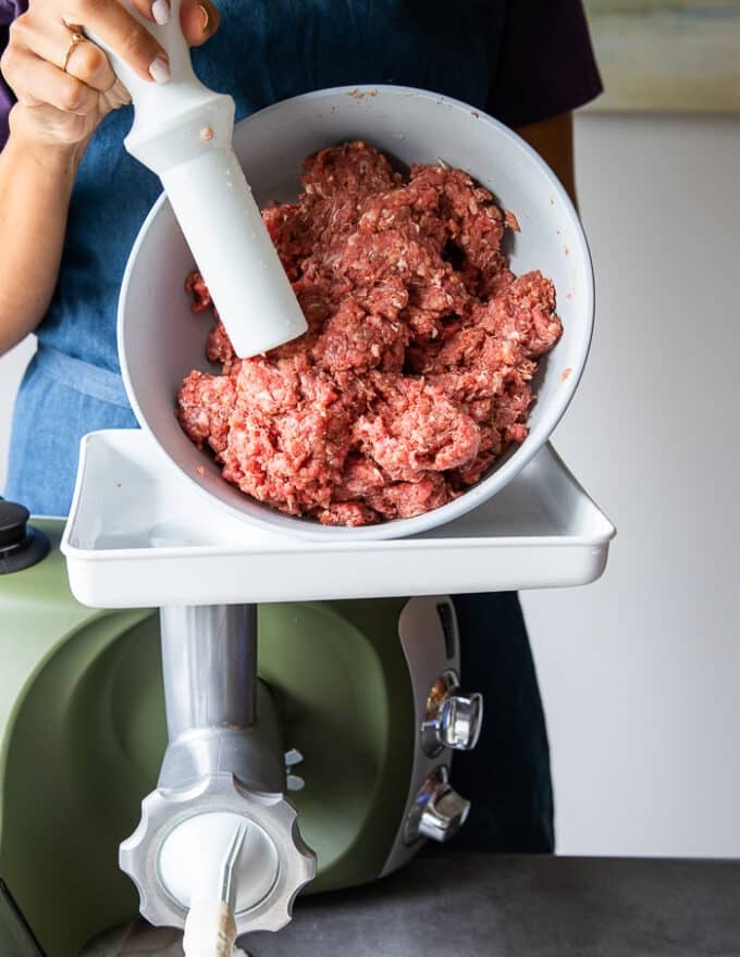 the seasoned sausage meat is added to a feeding tube while the casings are added to the other