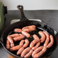 cooking sausage links in a skillet