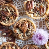 close up of one mini pecan pie on a white wooden block