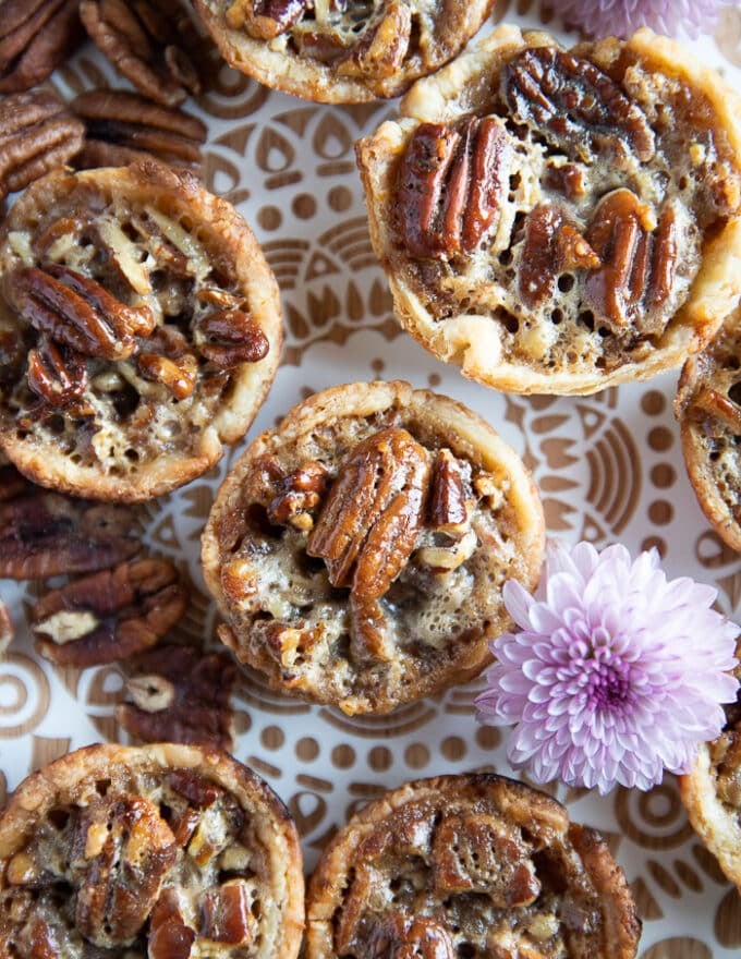 close up of one mini pecan pie on a white wooden block 