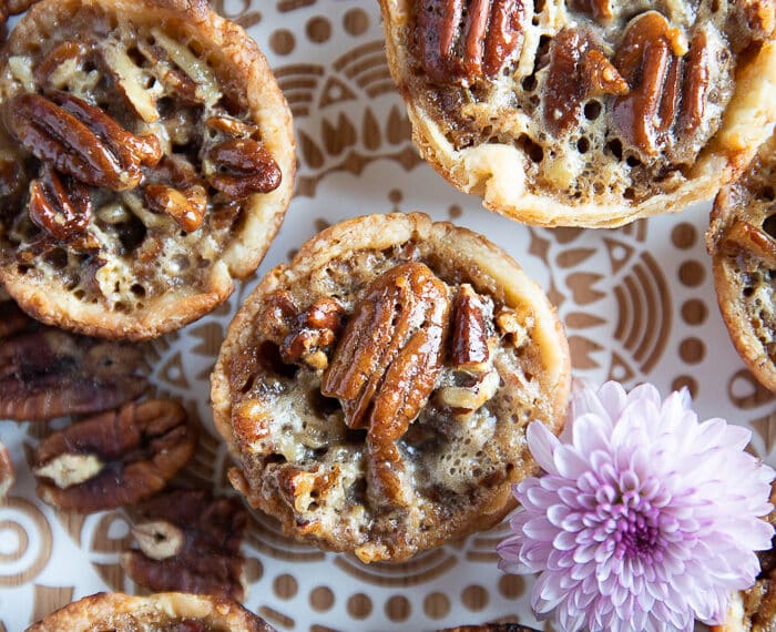 close up of one mini pecan pie on a white wooden block