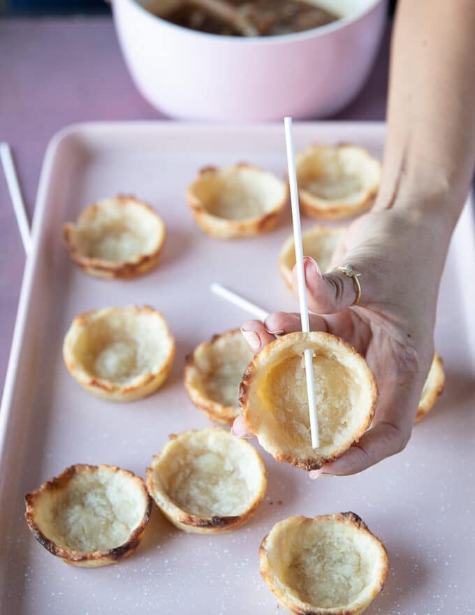 Optional way to serve the mini pecan pies is to make pecan pie pops by sticking a lollipop stick in the cooked pie crusts before adding in the filling and then baking them as usual