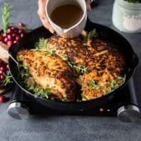 A hand pouring the stock over the turkey tenderloin recipe