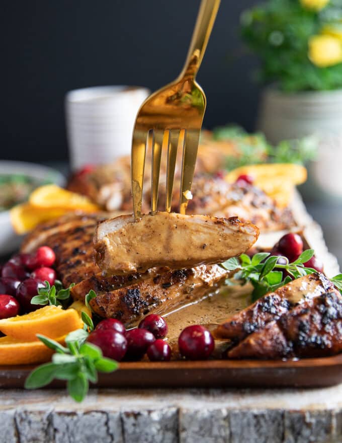A fork holding a piece of turkey tenderloin showing how juicy it is!