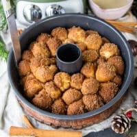 Cinnamon roll monkey bread baked and ready out of the oven. A knife is run around the pan to release the monkey bread