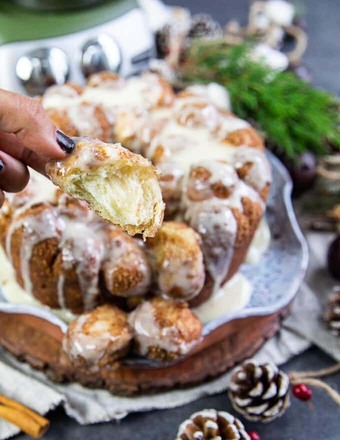 A bitten chunk of cinnamon roll monkey bread showing the fluffy inside of the dough