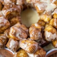 close up of monkey bread cinnamon rolls with cream cheese icing showing one piece