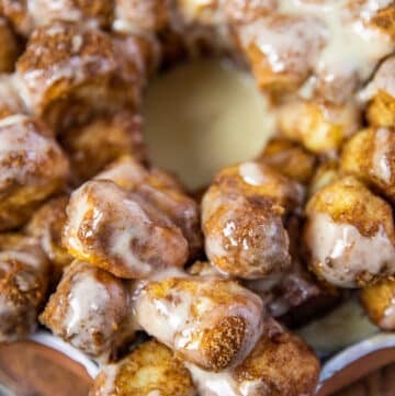 close up of monkey bread cinnamon rolls with cream cheese icing showing one piece