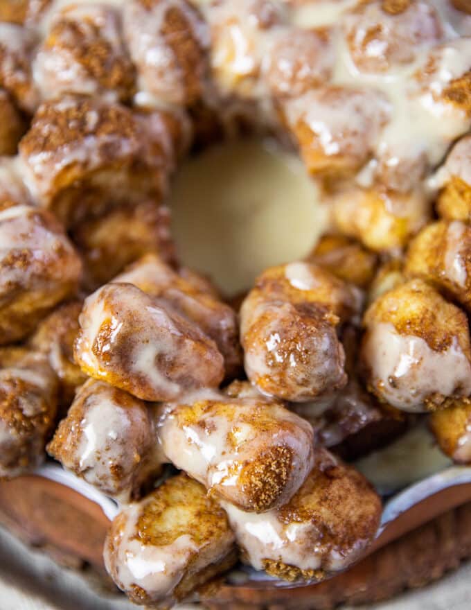 close up of monkey bread cinnamon rolls with cream cheese icing showing one piece 