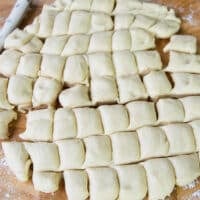 The patted dough is cut into 1 inch squares