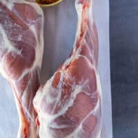 Two fresh Legs of lamb on a cutting board, trimmed